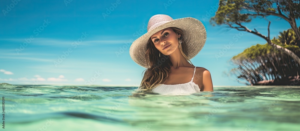 The woman immersed herself in the crystal-clear water, feeling the warm rays of the summer sun gently caress her skin as she enjoyed her beach vacation, embodying the concept of a carefree and