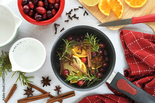 Making Christmas Scent to give as a gift - oranges, lemons, cranberries, cinnamon, star anise, cloves spices photo