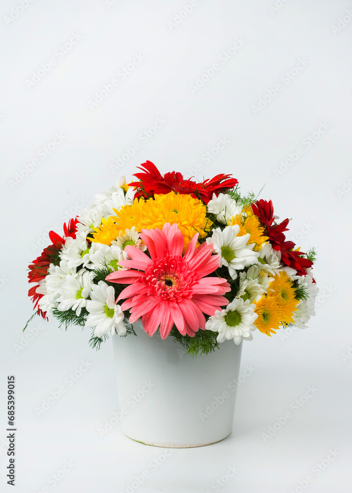 A vertical image of a beautiful pink and white carnations and baby’s breath bouquet in a glass vase with isolated on white background