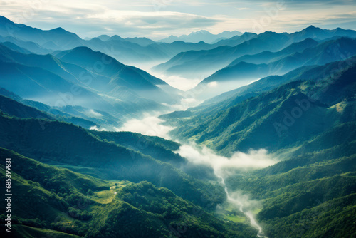A lush mountain range photographed from above, showcasing the majestic peaks, valleys, and winding rivers. © Hunman