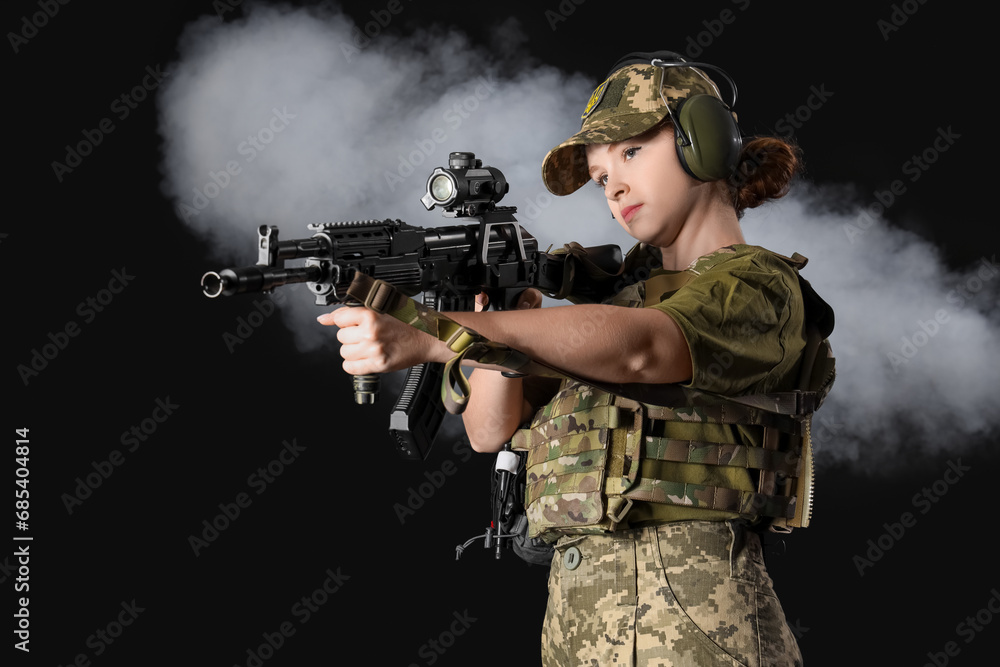 Young female soldier with assault rifle on dark background Young female soldier with assault rifle on dark background