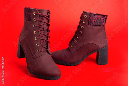 women's cherry demi-season ankle boots on red background. © kosoff