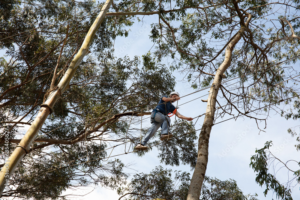 Fototapeta premium Person popping tree on ropes course