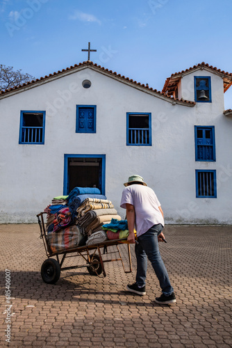 Seller carrying merchandise in front of the church known as a tourist spot in city Embu das Artes