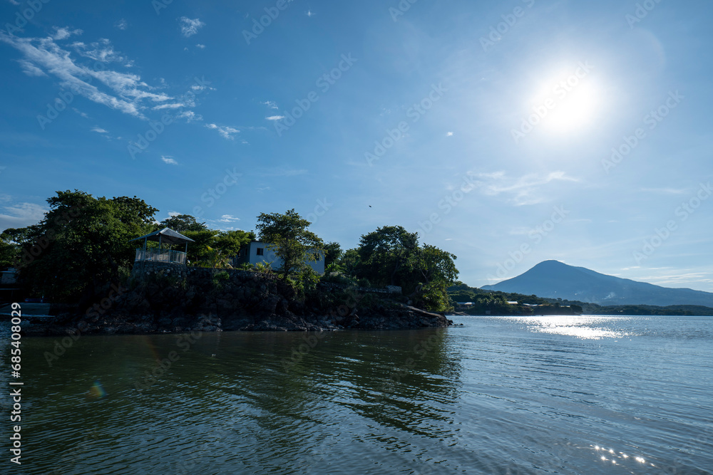 Paradisiacal Coastline Seen From Afar with Lush Vegetation Forest, and Colorful Houses by a Calm Ocean