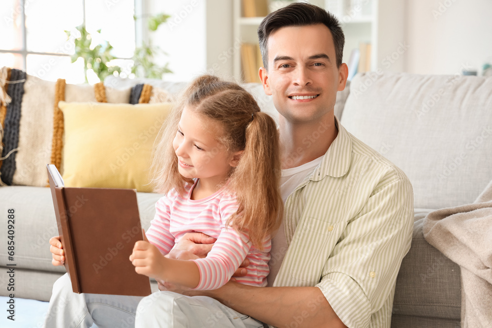 Cute little girl with her dad reading story at home Cute little girl with her dad reading story at home