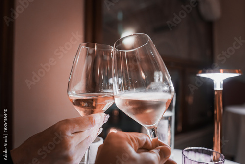 A couple toasting with white wine glasses at a cozy restaurant in Venice, Italy. The warm and inviting setting captures a beautiful moment in the romantic city.