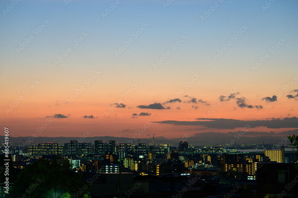 夜明け前の都市。神戸の高台から神戸・大阪のビル群と大阪湾をのぞむ