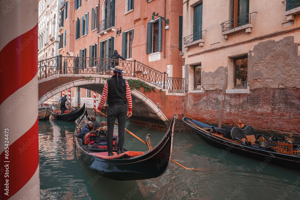 Experience the timeless beauty of Venice with this stunning image of gondolas gliding through the picturesque canals, showcasing the city's unique charm and historic atmosphere.