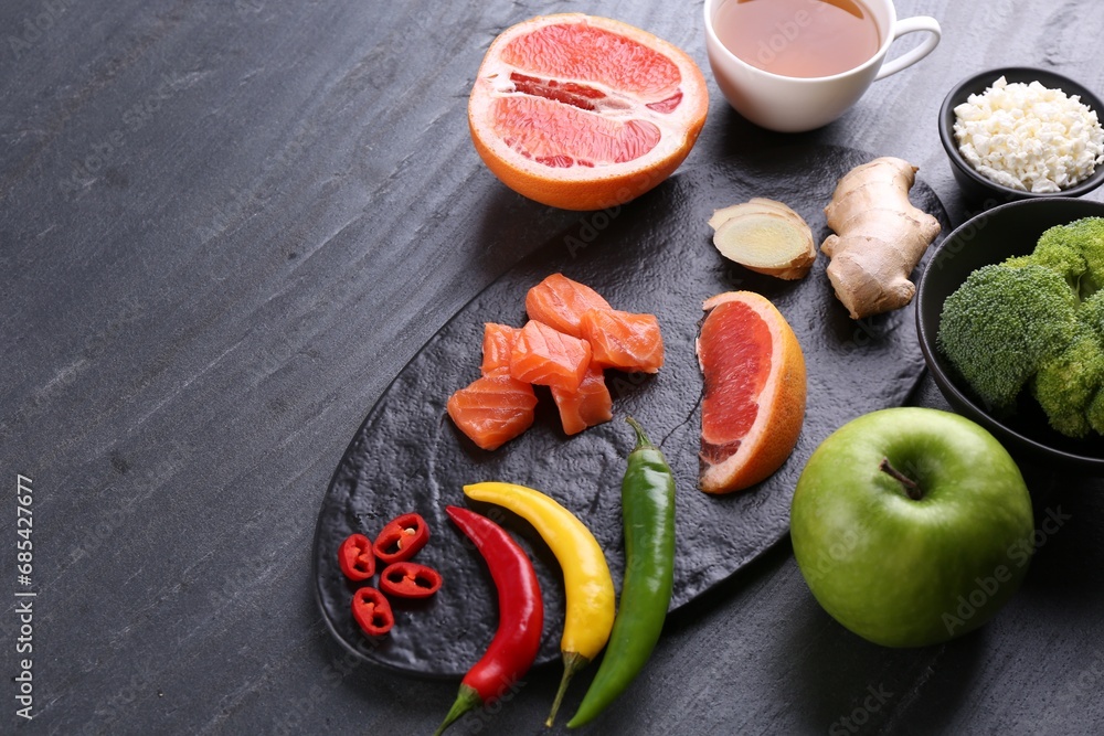 Metabolism. Different food products on dark grey table, space for text Metabolism. Different food products on dark grey table, space for text