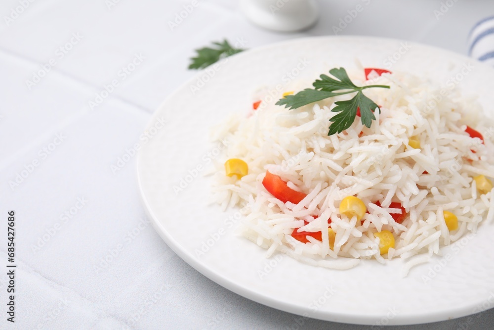 Delicious rice with vegetables and parsley on white table, closeup Delicious rice with vegetables and parsley on white table, closeup