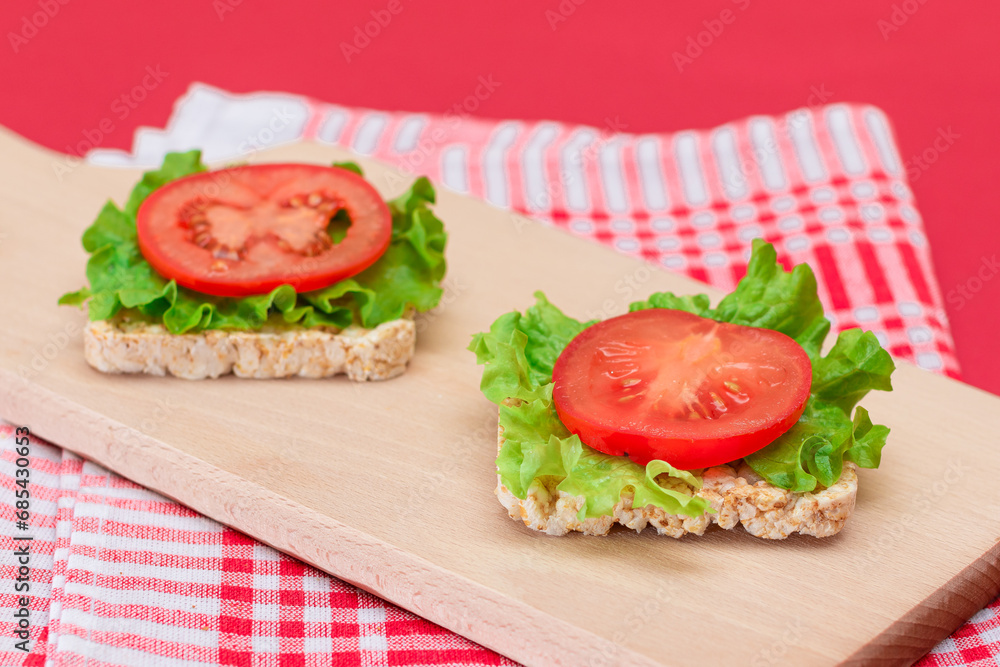 Rice Cake Sandwiches with Tomato and Lettuce on Wooden Cutting Board. Easy Breakfast. Diet Food. Quick and Healthy Sandwiches. Crispbread with Tasty Filling. Healthy Dietary Snack