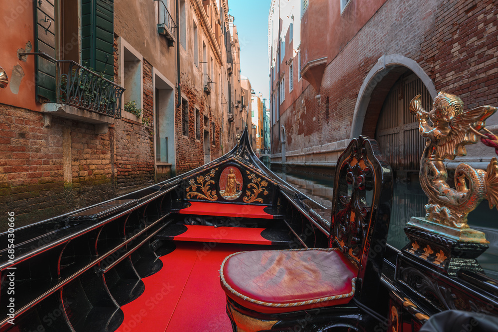 A serene canal in Venice, Italy, with a traditional gondola being steered by a gondolier. The image captures the timeless charm and beauty of a peaceful and romantic Venetian scene.