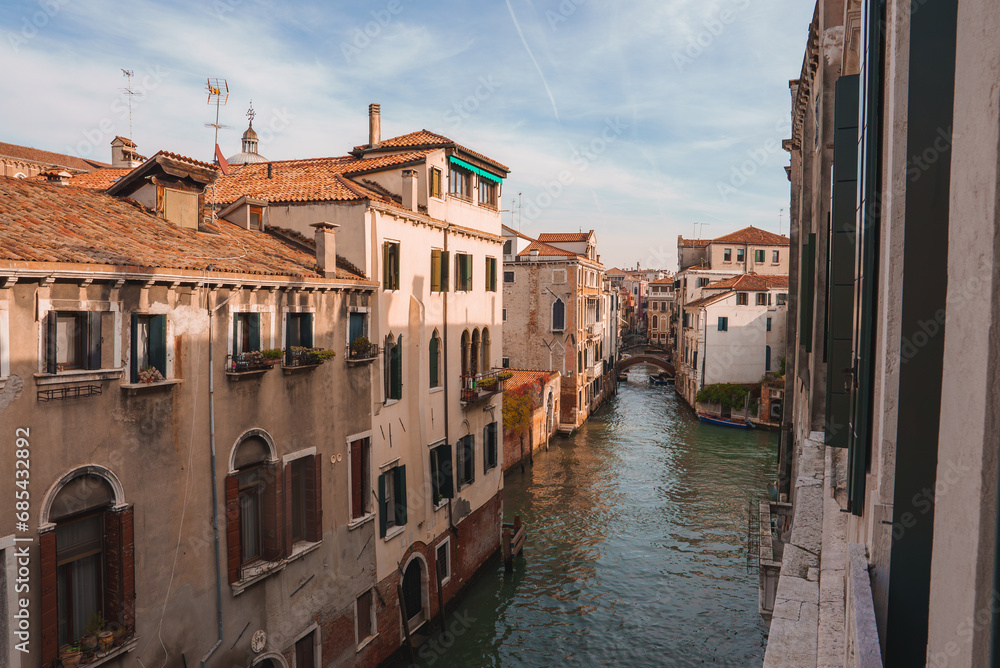 Experience the timeless beauty of Venice, Italy with this stunning view of a canal from a balcony. The iconic Venetian architecture and picturesque waterway capture the city's unique charm.