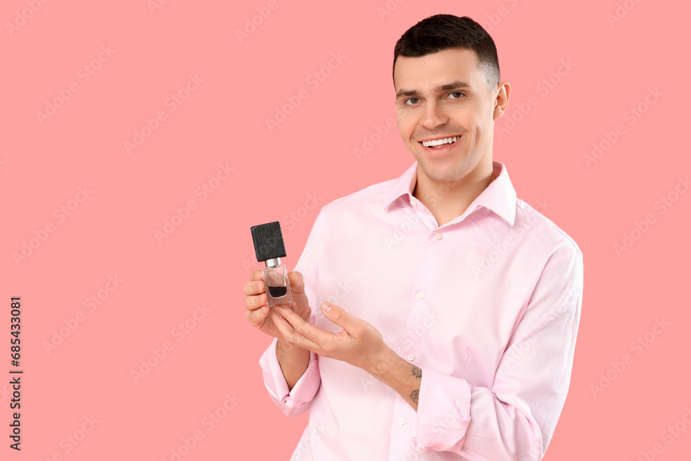 Young man with perfume on pink background Young man with perfume on pink background