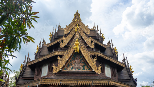 Picture of the Thai style sermon pavilion Consisting of a bouquet of raka leaves with a golden kanok pattern. It is topped with a statue of a golden angel. The gable is a figure of Buddha.