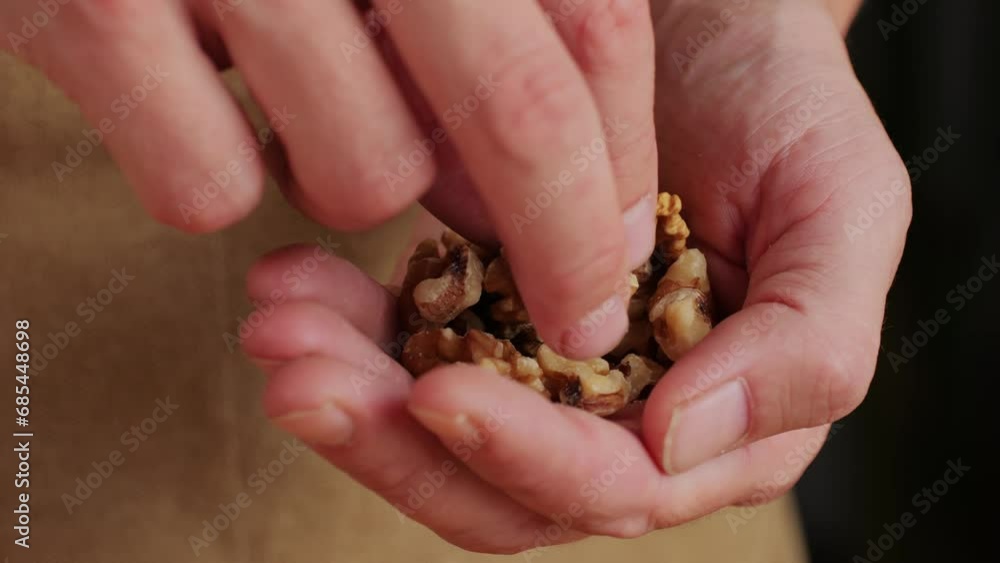 Walnuts without shell in man hand close-up macro. Peeled nuts. Healthy snacks. Product rich in minerals and vitamins.