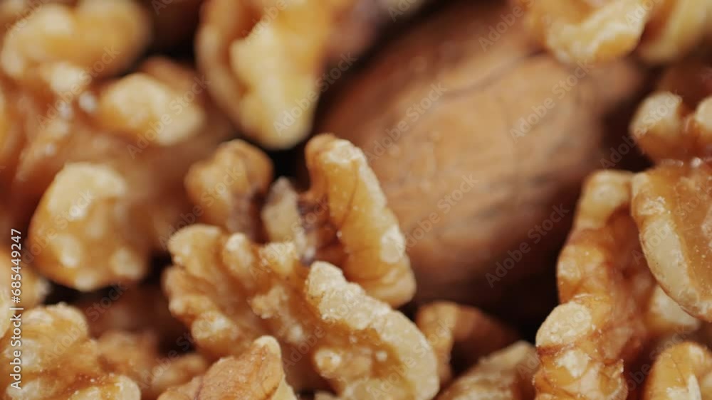 Mix of walnuts in red plate close-up macro. Walnut in shell, walnut without shell. Peeled nuts. Healthy snacks. Product rich in minerals and vitamins. Mix of walnuts in red plate close-up macro. Walnut in shell, walnut without shell. Peeled nuts. Healthy snacks. Product rich in minerals and vitamins.