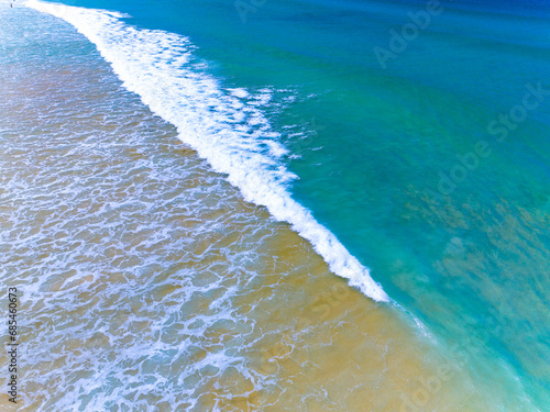 Aerial view of Waves crashing on sandy shore,Sea surface ocean waves background,Top view beach background