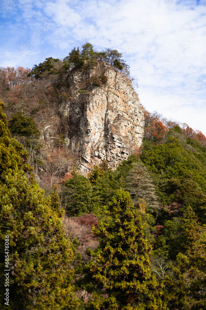 秋の青空と紅葉の岩山の風景