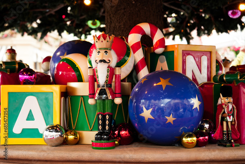 Nutcracker Soldier toy, drum, candy cane, star ball, alphabet block and metallic ornaments decoration with big pine tree celebrate in festive season at the Merry Xmas carnival