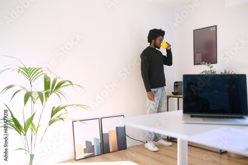 man drinking coffee during work break at office. Relaxed moment during business work photo