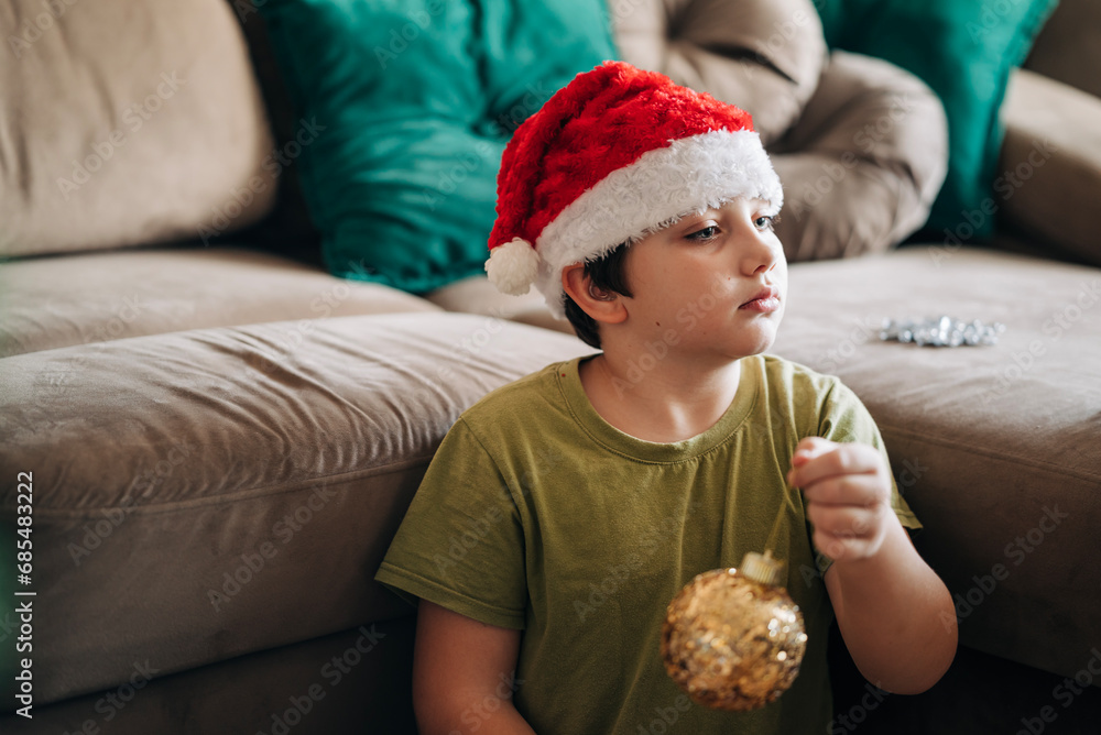 Kid boy decorating Christmas tree put off balls from the box authentic real celebration image lifestyle. Xmas with family children fun at cozy home Kid boy decorating Christmas tree put off balls from the box authentic real celebration image lifestyle. Xmas with family children fun at cozy home