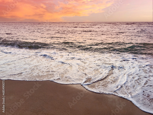 Sunset scene with wave water in the Tropical summer beach with  sandy beach background