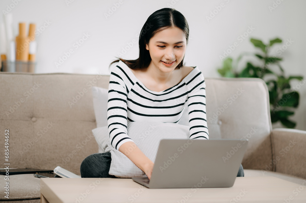Asian woman using the smartphone and tablet on the sofa at home. Asian woman using the smartphone and tablet on the sofa at home.