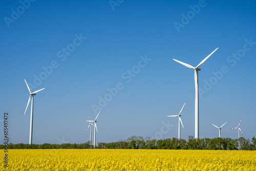 Wind turbines and a field of yellow rapeseed seen in Germany photo