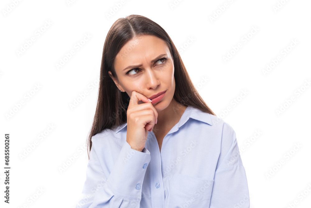 portrait of a stylish well-groomed young brunette caucasian woman with straight hair dressed in a blue blouse looking to the side attentively on a white background with copy space portrait of a stylish well-groomed young brunette caucasian woman with straight hair dressed in a blue blouse looking to the side attentively on a white background with copy space