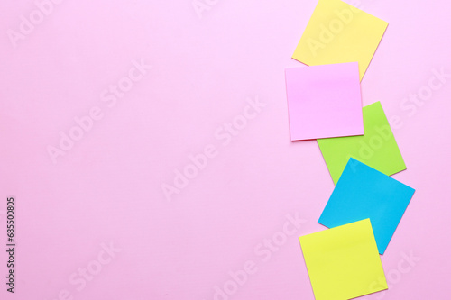 Blank multicolor sticky notes on pink background.