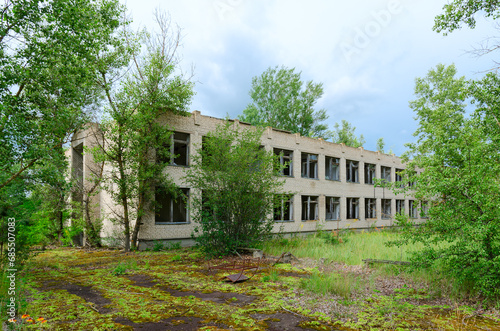 Two-story brick building of abandoned school in resettled village of Orevichi in exclusion zone of Chernobyl, Belarus