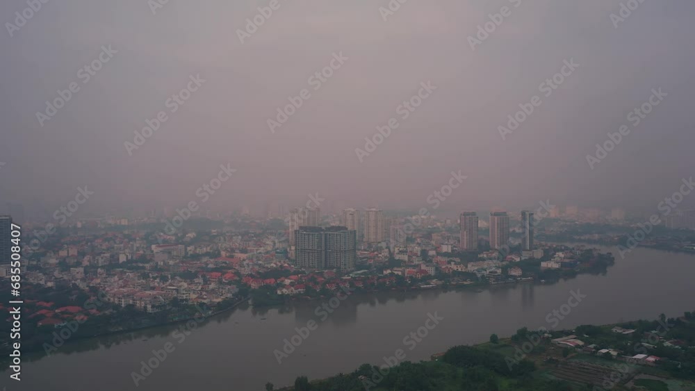 Aerial view of air pollution in southeast asian city. Location is Ho Chi Minh City, Vietnam with Saigon River and city skyline. Panning reveal shot. Aerial view of air pollution in southeast asian city. Location is Ho Chi Minh City, Vietnam with Saigon River and city skyline. Panning reveal shot.