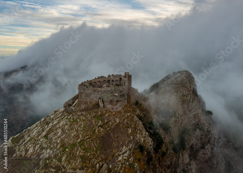 drone view of the Castello del Volterraio shrouded in morning fog and cloud photo