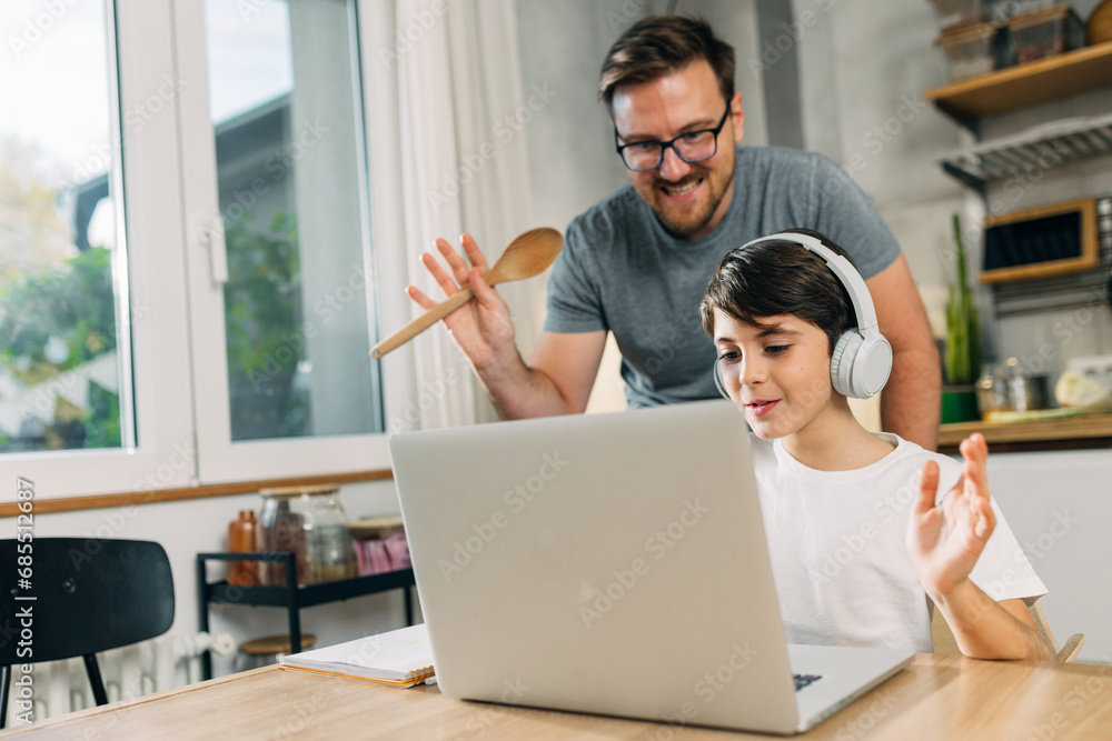 Father and son waving at the camera on laptop. Father and son waving at the camera on laptop.