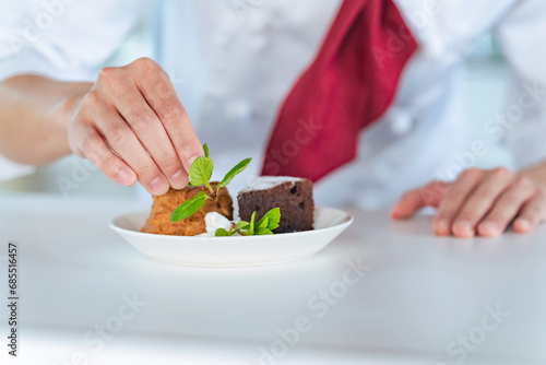 Pastry chef serving dessert plates.