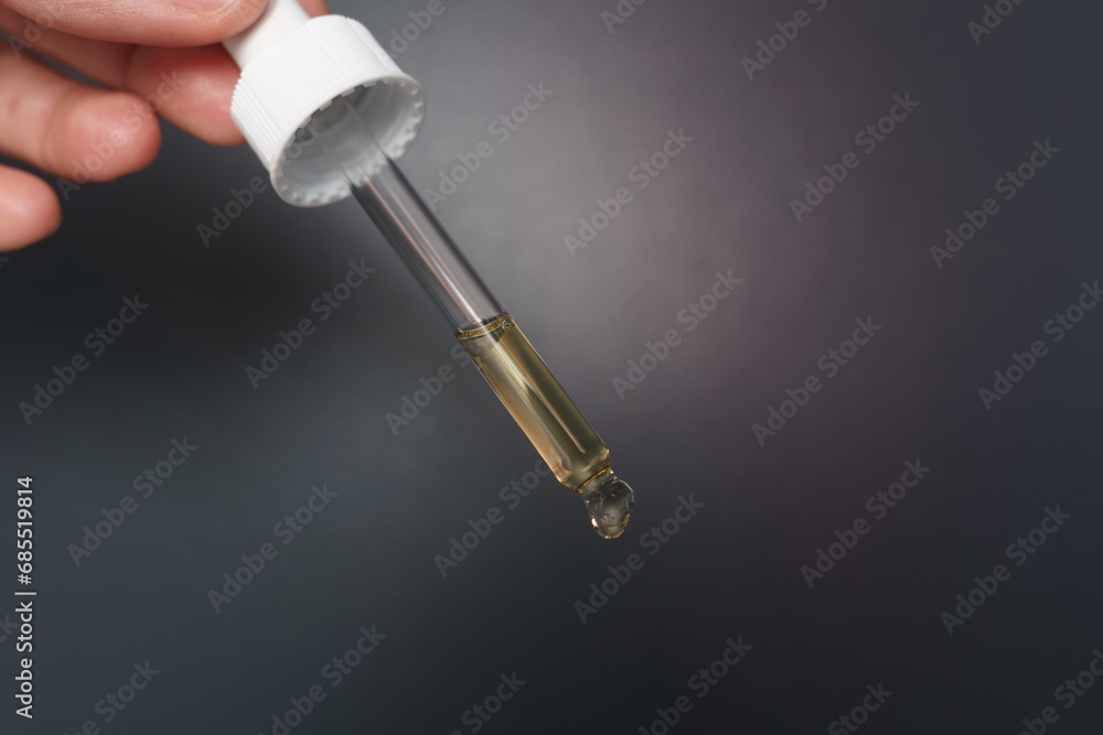 Hands holding a dropper filled with serum ready for application Hands holding a dropper filled with serum ready for application