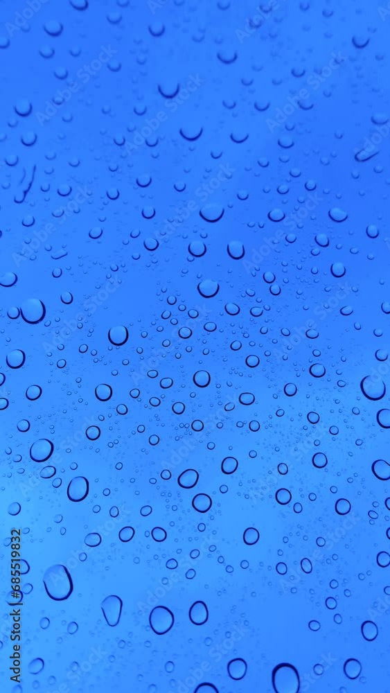 Rain drops dripping down blue window Rain drops dripping down blue window