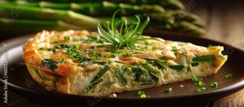 The rustic frittata, a baked pie-like dish loaded with nutritious vegetables like asparagus, is topped with parmesan and a generous sprinkling of herbs for a fresh and flavorful meal. The green and