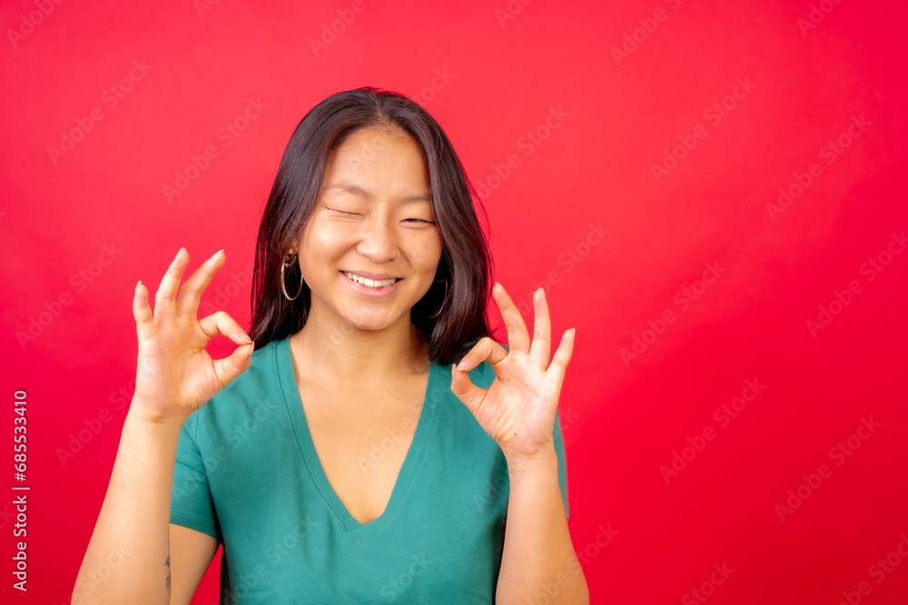Chinese woman gesturing ok with hands and winking Chinese woman gesturing ok with hands and winking