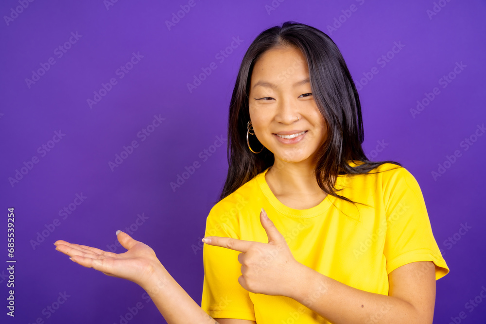 Positive chinese woman pointing to the side Positive chinese woman pointing to the side