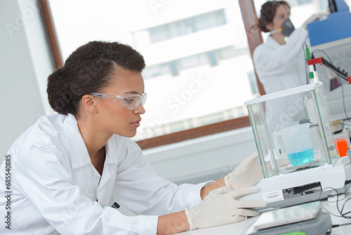 female lab worker look for chemical data in laboratory