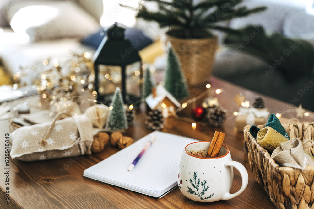 Pen on notepad at home on winter holidays xmas. Goals plans make to do and wish list for new year christmas concept,l writing in notebook. Christmas decoration, gift boxes. 