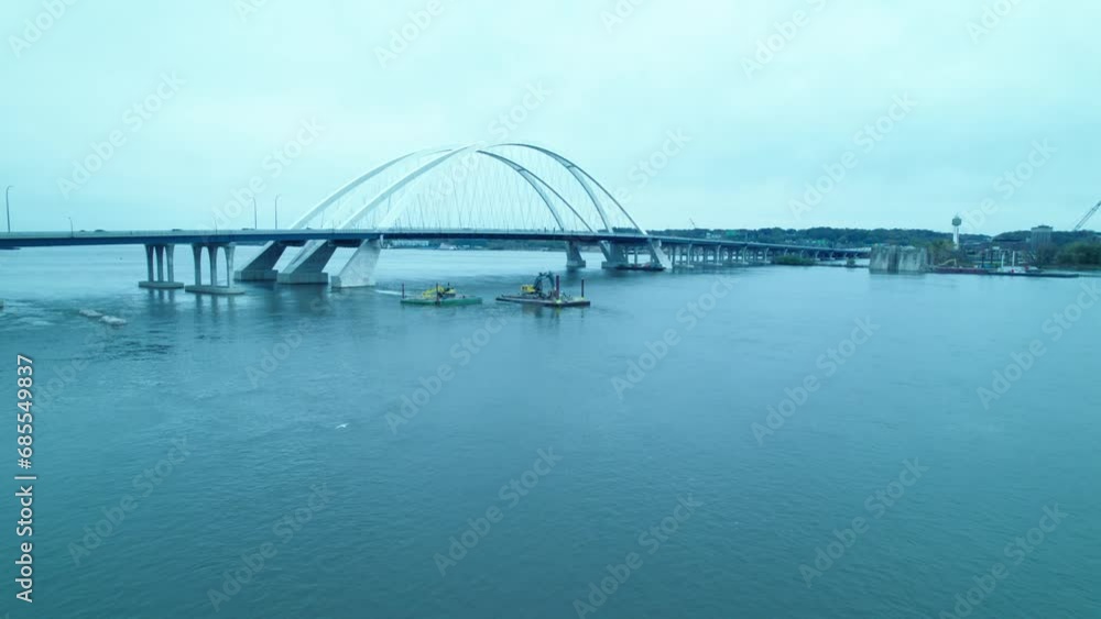 Aerial of construction machineries on floating docks pontoon on mississippi river at Centennial Bridge in Davenport, Iowa, USA. Aerial of construction machineries on floating docks pontoon on mississippi river at Centennial Bridge in Davenport, Iowa, USA.