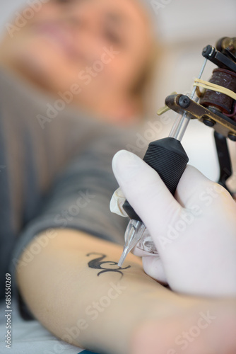 applying tattoo on the arm photo