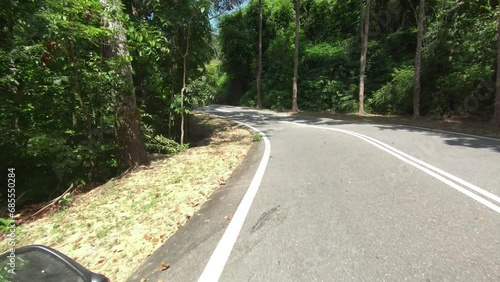POV action camera shot riding a scooter, backpacking on Langkawi. Smooth roads, long winding corners, touristy. photo