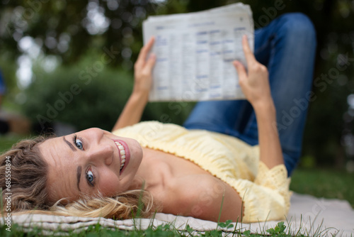 young girl lying on the grass in the park photo