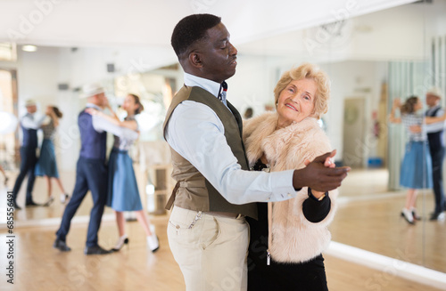 Man and mature woman learning to dance classical ballroom dance