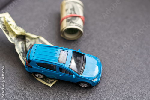 Saving money to buy a car. Toy car with money cash